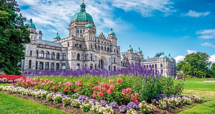 A grand historical building with vibrant flowers in the foreground.