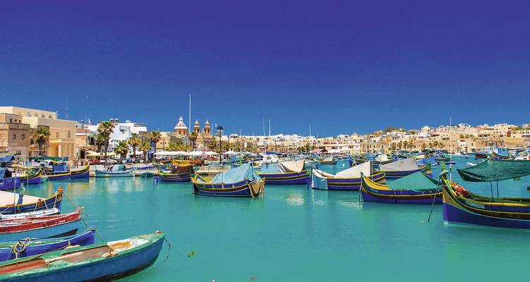 Harbor with colorful boats and blue water under a clear sky