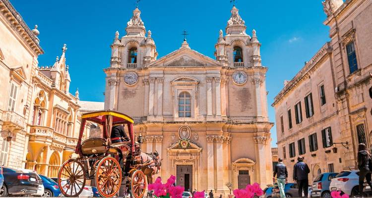 Historic church and buildings in a square with clear sky