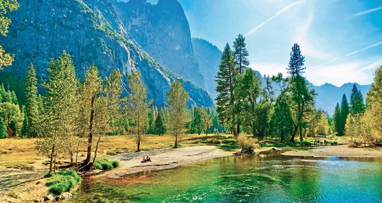 Klarer Fluss, der hohe Granitfelsen und Kiefernbäume im Yosemite-Nationalpark spiegelt.