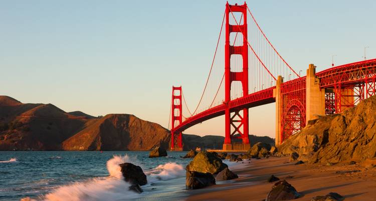 Puente Golden Gate con olas del océano e iluminación del atardecer