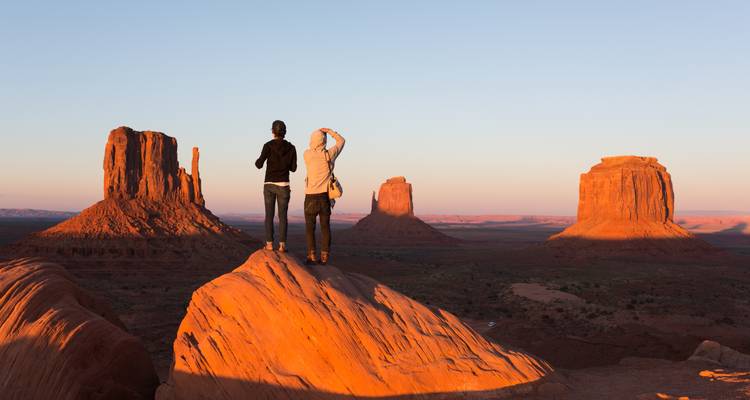 Dos personas observando Monument Valley al atardecer.