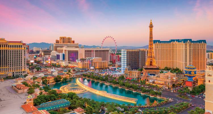 Colorful view of Las Vegas city with landmarks and bright lights at sunset.