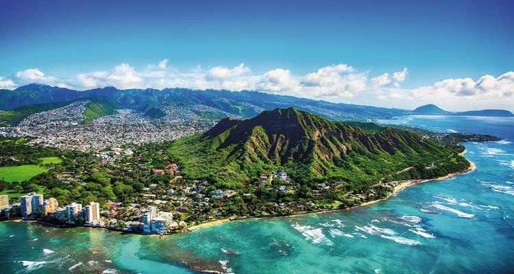 Panorama aéreo de Waikiki en Honolulu y el exuberante cono volcánico de Diamond Head rodeado por el océano turquesa.