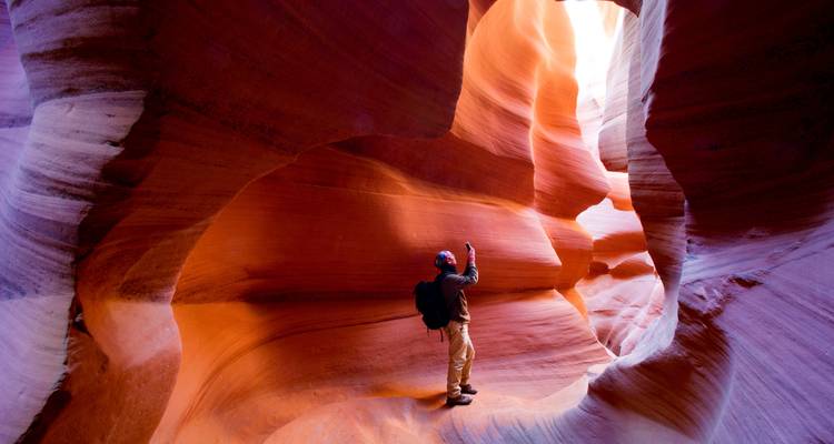 Una persona explorando las curvas coloridas de un cañón.