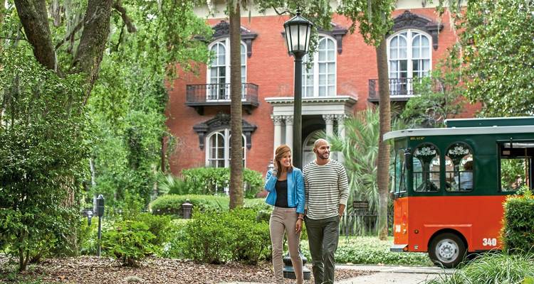 Couple marchant dans un quartier historique avec de la verdure.