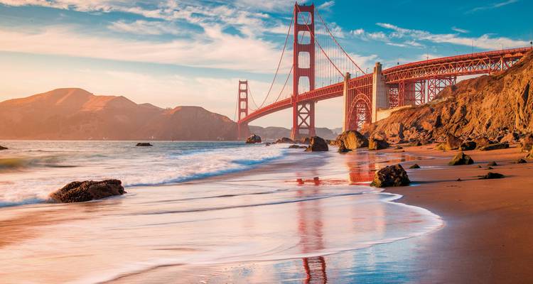 Pont du Golden Gate vu depuis une plage de sable au coucher du soleil.