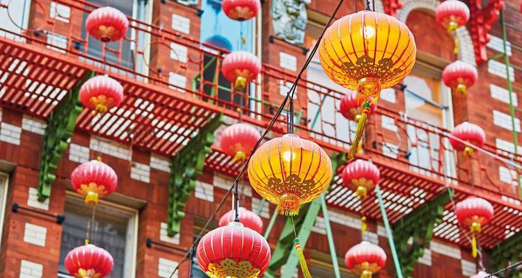 Des lanternes en papier colorées suspendues dans un cadre de rue vibrant.