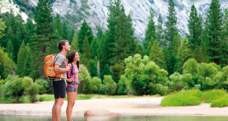 Deux randonneurs profitant d'une vue panoramique dans une zone boisée.