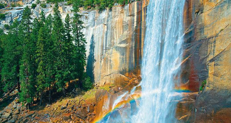 Ein atemberaubender Wasserfall mit einem Regenbogen im Nebel.