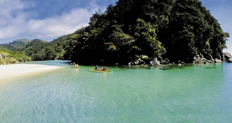 Personas navegando en kayak en aguas cristalinas color turquesa.