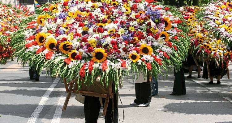 Feestelijke parade met grote, kleurrijke bloemstukken.