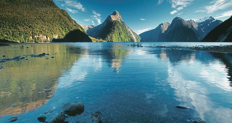 Scène au bord du lac avec des montagnes se reflétant dans l'eau.