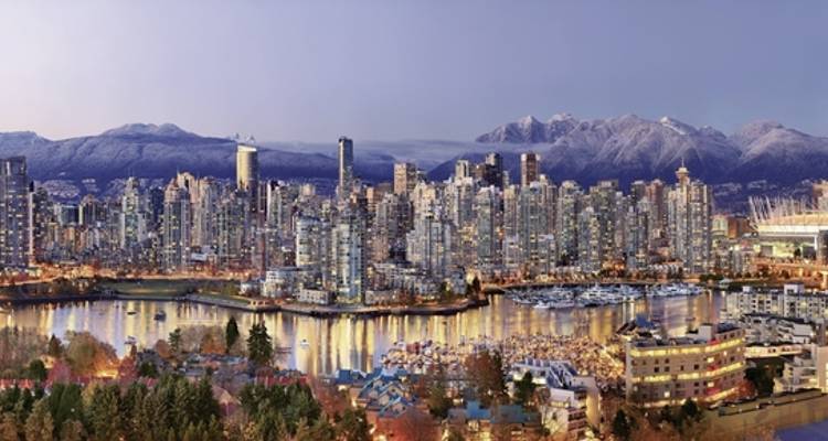 Skyline einer Stadt mit Bergen im Hintergrund.