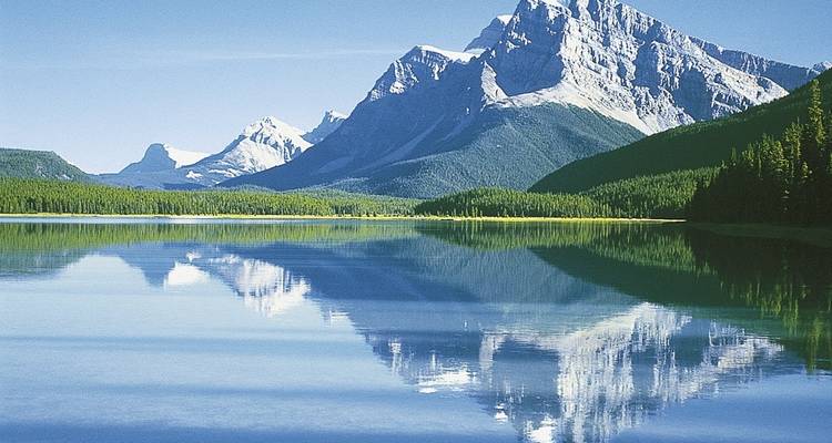 Scenic mountain range reflected in a calm lake.