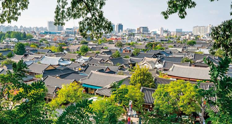 Traditionelle Stadtlandschaft mit koreanischen Hanok-Dächern inmitten einer modernen Stadt.