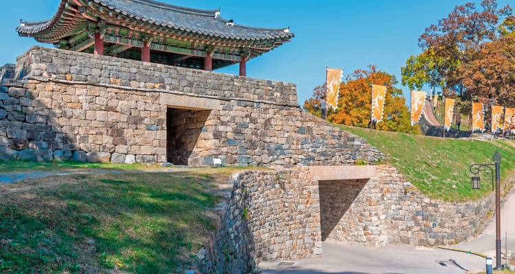 Steinerne Festungsmauern mit einem traditionellen koreanischen Tor.