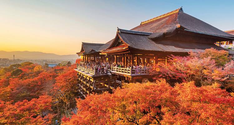 Temple Kiyomizu-dera entouré de feuillage d'automne au coucher du soleil.