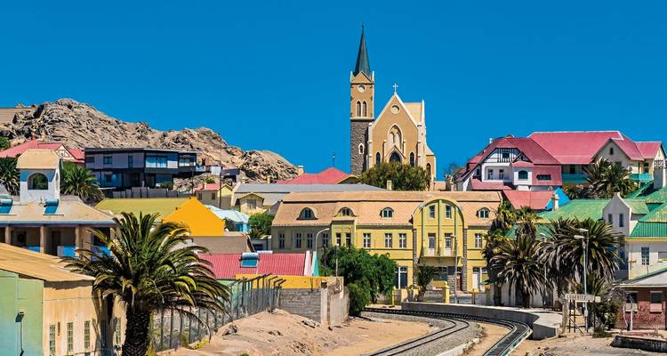 Kleurrijke historische gebouwen met een kerk op de achtergrond.