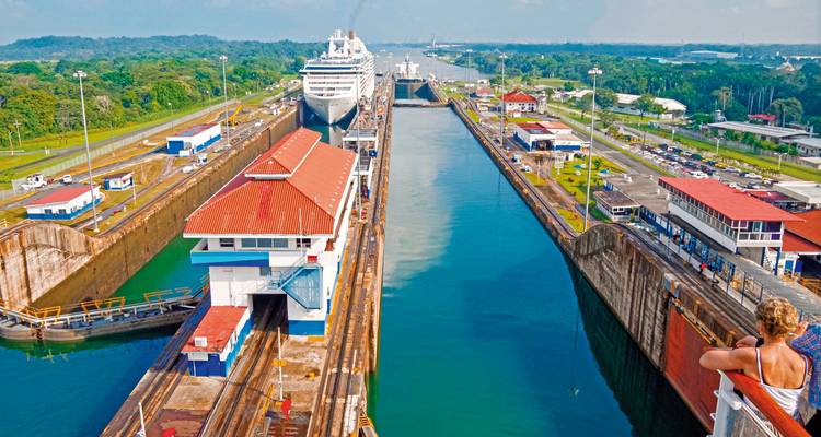 Het Panamakanaal met een cruiseschip dat door de sluizen vaart, toeristen die toekijken.