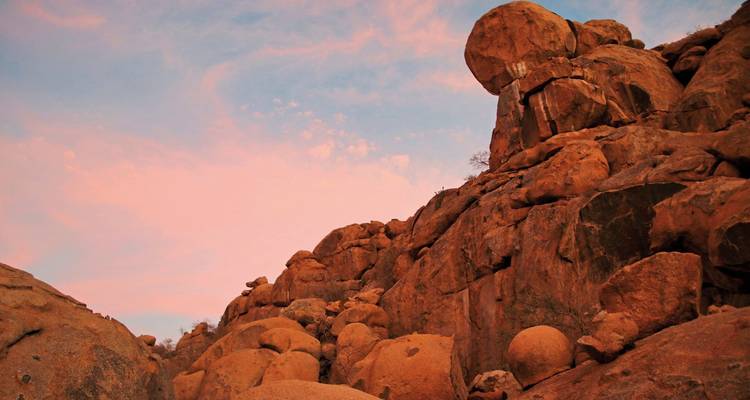 Rotsachtig terrein met rotsblokken onder een zonsonderganglucht.