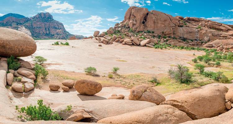 Rotsformaties in een uitgestrekt open gebied met een blauwe lucht.
