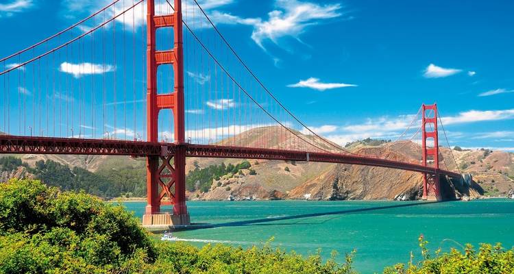 Puente Golden Gate con cielos azules y colinas verdes.