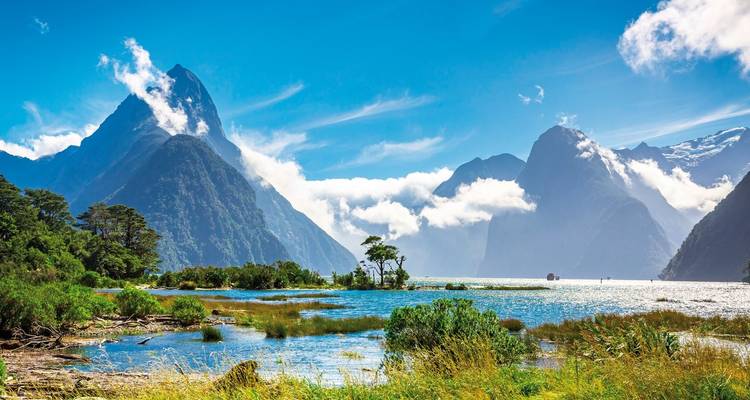 Scenic landscape of mountains and water with a clear blue sky.