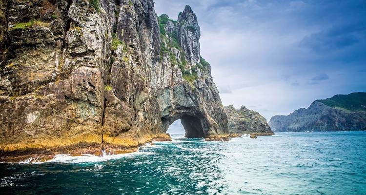 Rugged coastal rock formation with a sea cave.