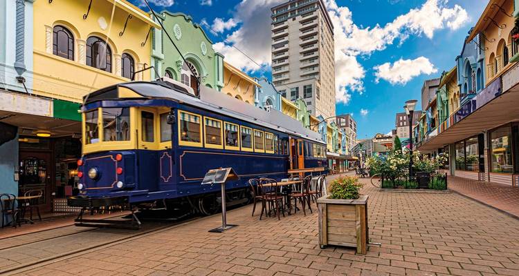 Tram on a vibrant street with colorful buildings.