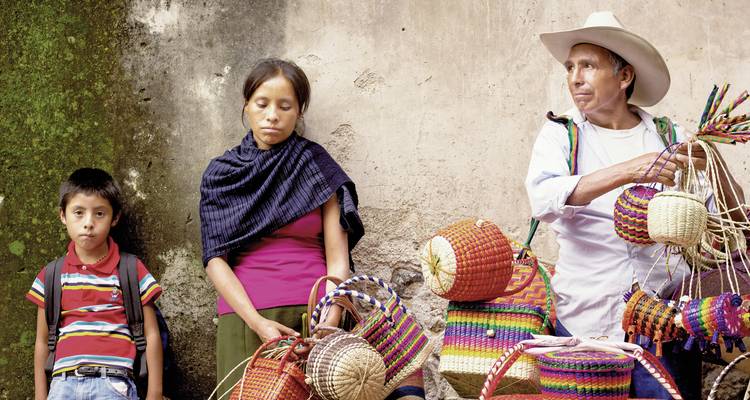 Indigene Menschen, die bunte gewebte Körbe zeigen.