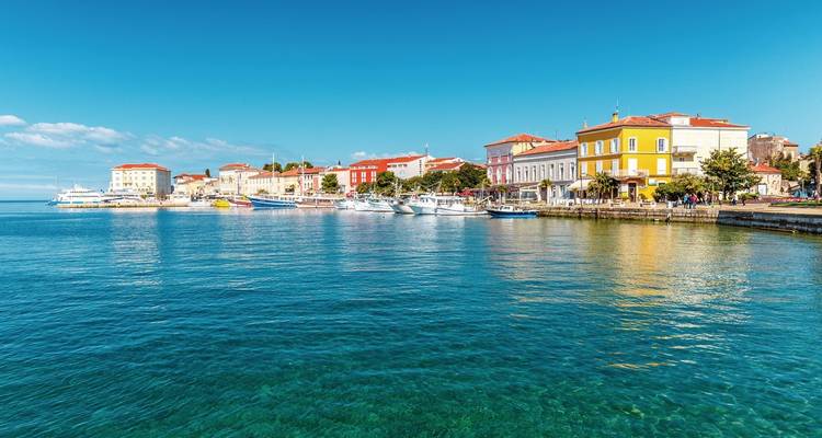 Bunte Gebäude entlang einer Uferpromenade in einer Küstenstadt.