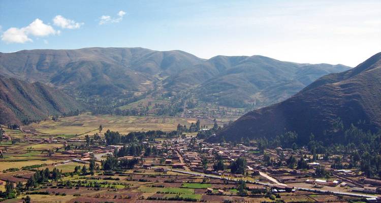 Luftaufnahme eines ländlichen Tals mit Feldern und Bergen.