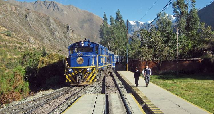 Zug fährt durch eine malerische Berglandschaft.