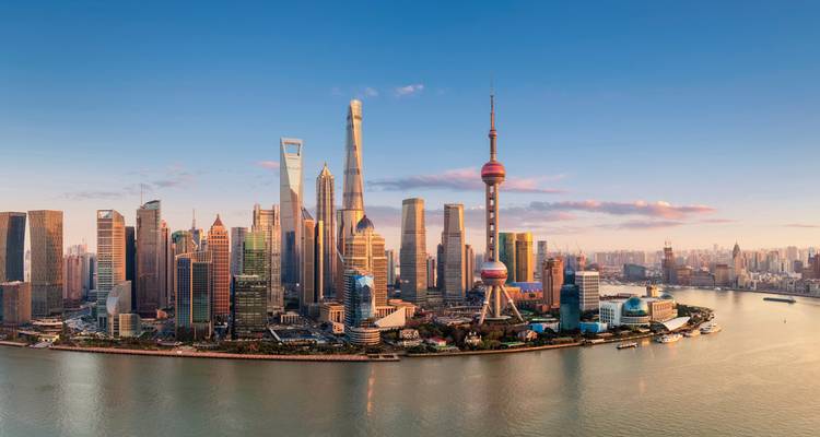 Shanghai city skyline with the Huangpu River at sunset.
