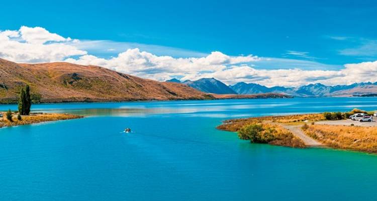 Lac bleu avec des montagnes sous un ciel clair et lumineux.