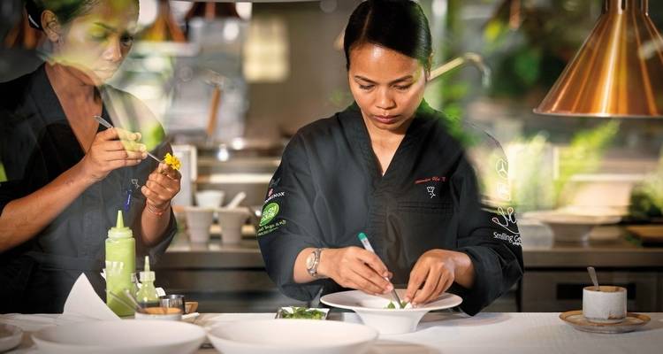 Chef preparing food with focus and precision in a kitchen.