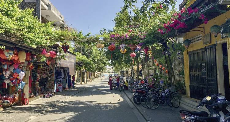 Charmante straat met versierde bomen en motorfietsen.