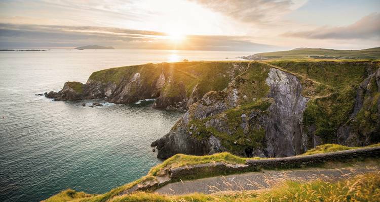 Sunset over dramatic coastal cliffs.