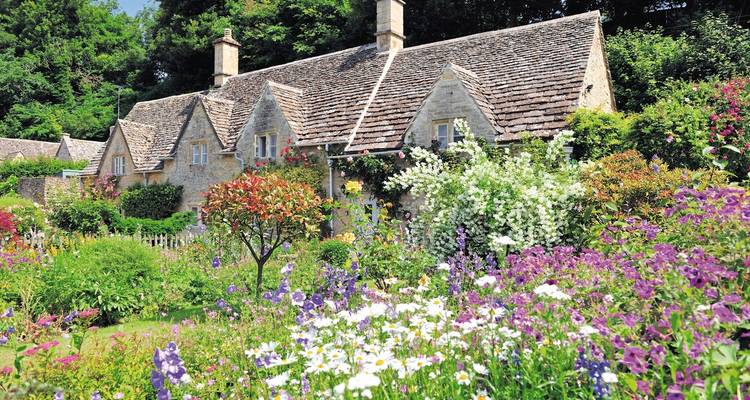 Charming stone cottage surrounded by a vibrant flower garden.