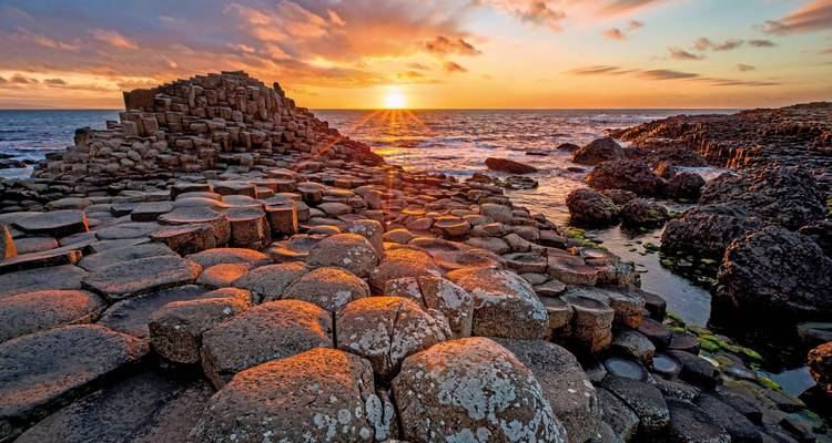 Les colonnes de basalte distinctives de la Chaussée des Géants au coucher du soleil.