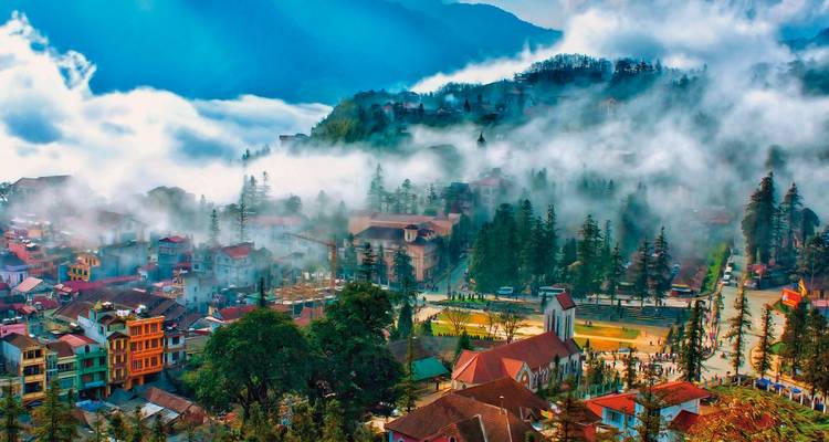 Luchtfoto van een met mist bedekte bergachtige stad met kleurrijke gebouwen.