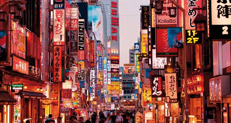 Überfüllte, neonbeleuchtete Straße in Tokio, vollgepackt mit Schildern und Abendshoppern.