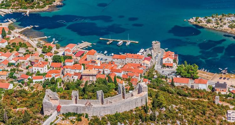 Aerial view of a coastal town with historical fortress.