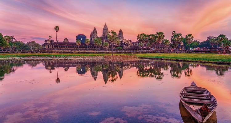 Angkor Wat weerkaatst in een vijver tijdens zonsondergang.