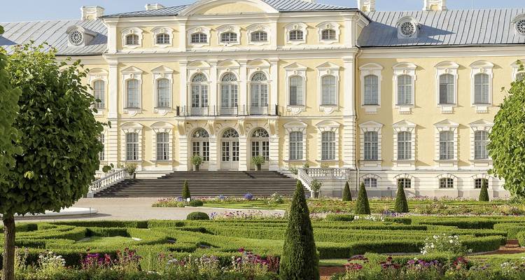 Eleganter Palast mit gepflegten Gärten und einer symmetrischen Fassade.