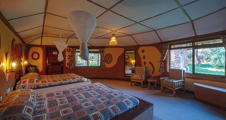 Interieur van een logekamer met bedden en ramen.