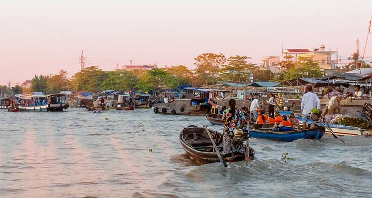Bustling floating market with boats filled with people and goods.