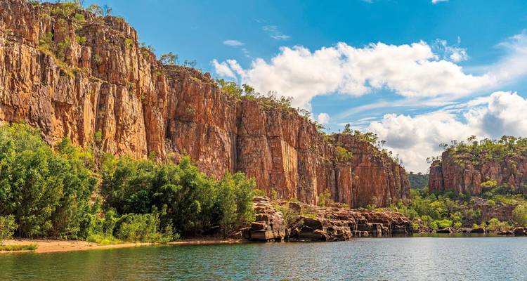 Dramatische Klippen, die sich über einen Fluss in einer üppigen Landschaft erheben.