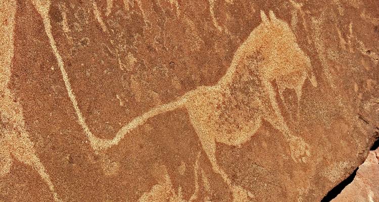 Ancient rock art depicting an animal on a stone surface.